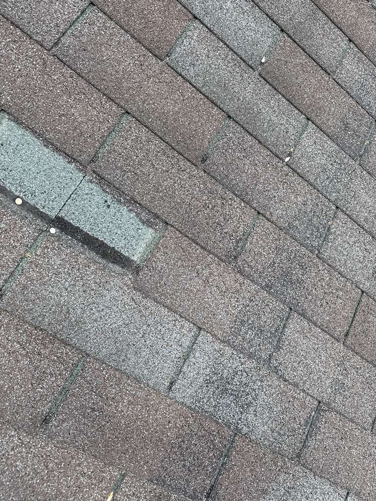 Roofer installing shingles